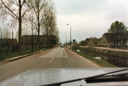 847739 Gezicht over de weg Dorp in Benschop vanuit de auto, voor de herinrichting van de weg; rechts de Benschopper ...